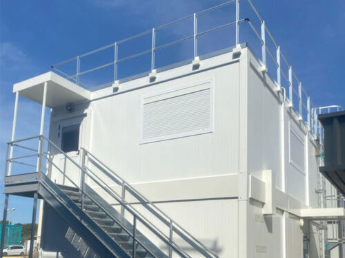 RÉALISATION : Pose d’un bâtiment préfabriqué en R+1 avec garde-corps et échelle crinoline, installation électrique, réseau informatique et climatisation.